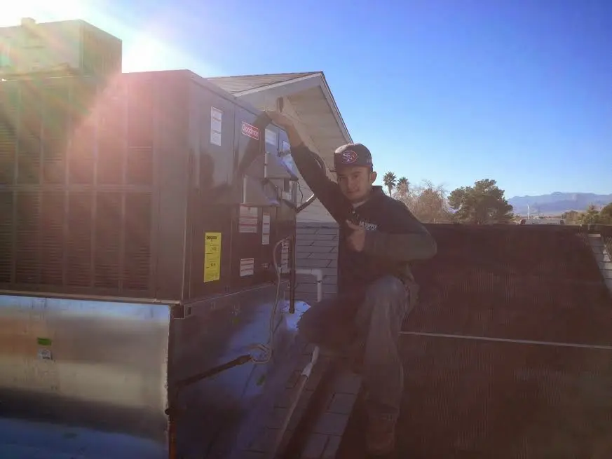 HVAC technician performing Boiler Repair on a rooftop unit in Caldwell